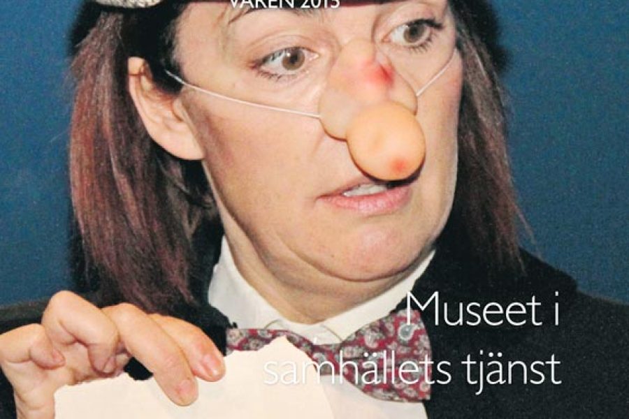 Kvinna med clownnäsa och keps håller papper med motiv på, troligen från en teaterpjäs. Text: "Länsmuseet Kalmar Våren 2015". Fraser: "Museet i samhällets tjänst", "Boka barnkalas på länsmuseet!", "Ny utställning: Ett län i beredskap".