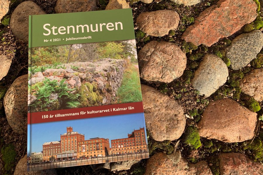 Boken "Stenmuren" ligger på en mark av ojämna stenar. Omslaget visar en stengärdsgård omgiven av grönska och en bild av ett rött tegelhus. Text: "Nr 4 2021 Jubileumsskrift. 150 år tillsammans för kulturarvet i Kalmar län."