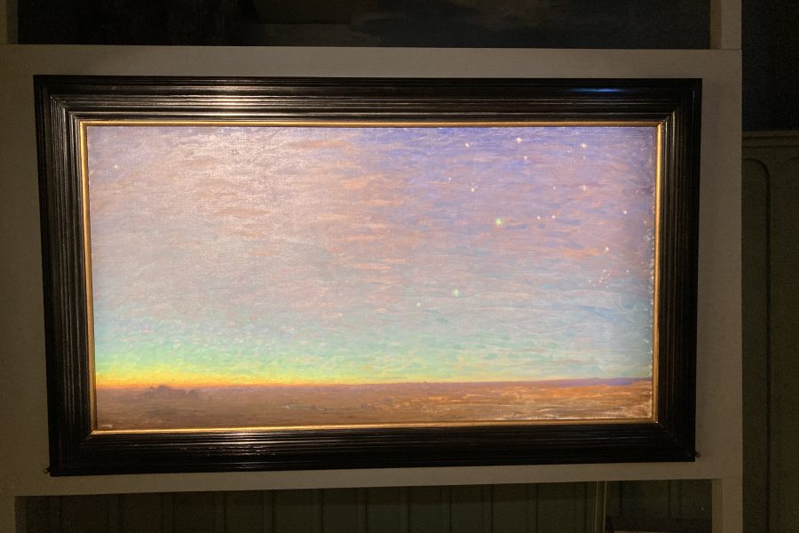 En målning visar en soluppgång över ett öppet landskap. Himlen övergår från mörkblått till ljusare nyanser mot horisonten och små stjärnor syns ovanför. Ramen är mörk och tjock, vilket betonar konstverkets detaljer.