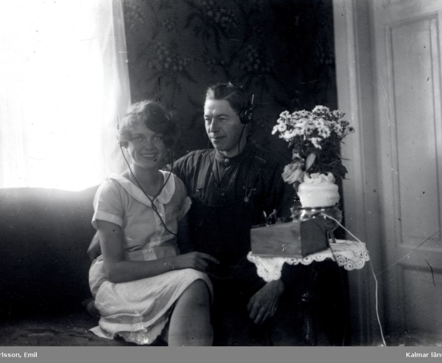 Photographie en noir et blanc d'un homme et d'une femme portant des écouteurs.