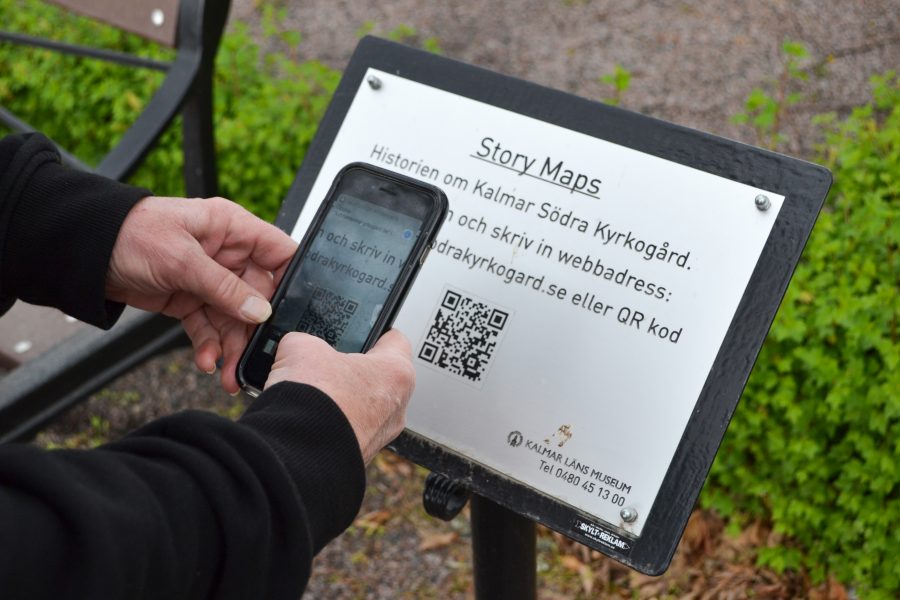 A person has a mobile phone and points it at a sign